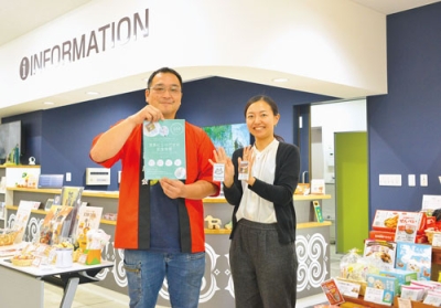 写真：新駅舎完成を記念したキーホルダーをＰＲする勝間会長（左）ら