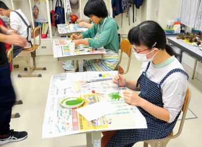 写真：樹木の葉を使った工作を楽しむ生徒ら