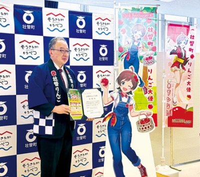 写真：イベント「そうべつりんごめぐり」オープニングセレモニーで、町りんご大使「木下ひなた」へ委嘱状を贈る田鍋町長（左）