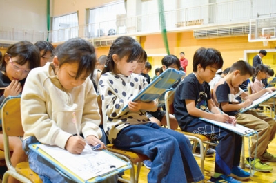 写真：紙芝居に登場する村長の立て札について考える伊達西小児童ら
