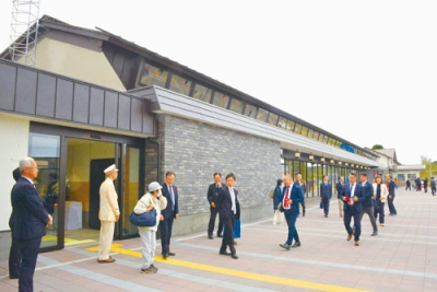 写真：テープカットでエレベーターや新駅舎の完成を祝う参加者たち