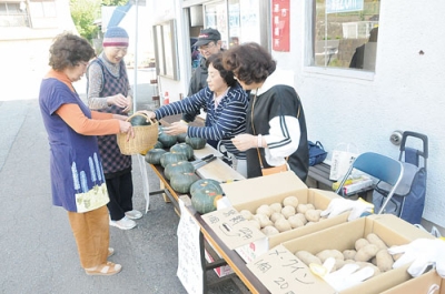 写真：新鮮野菜を購入する地域住民ら