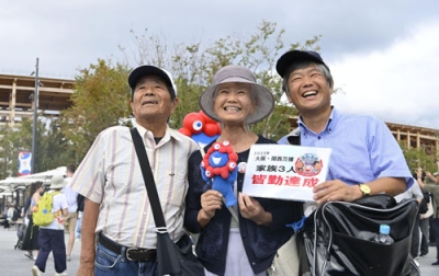 写真：全１８４日来場の「皆勤賞」を達成した「万博おばあちゃん」として知られる山田外美代さん（中央）＝１３日午前、大阪市此花区の夢洲