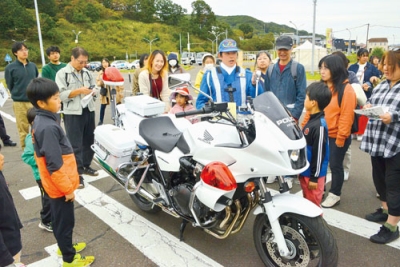 写真：白バイ隊員からバイクについて説明を受ける来場者たち