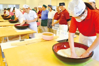 写真：混成チームが一丸となってそば打ちに取り組んだ対抗戦