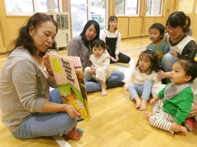 写真：英語の絵本に見入る子どもたち（提供写真）