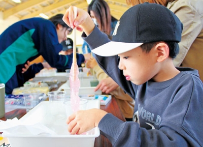 写真：真剣な表情でスライム作りに熱中する子ども
