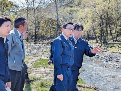 写真：河川の被害状況について説明を受ける船橋氏（右から２人目）