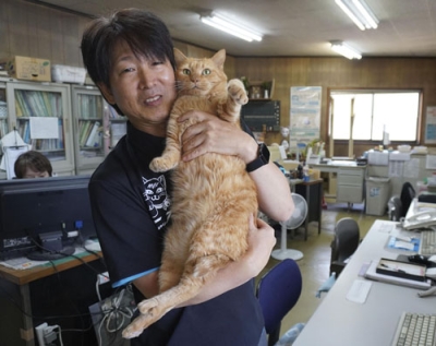 写真:東和交通の佃滋裕社長と「ニャルソック隊」隊長の「みゃー」=広島県福山市