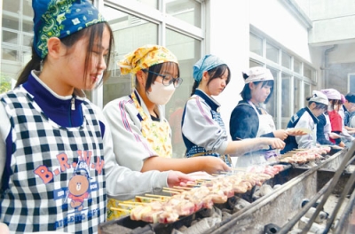 写真：室蘭やきとりを炭火で焼き上げる生徒たち