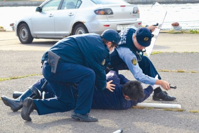 写真：逃走するテロリスト役を制圧する海保職員と警察官