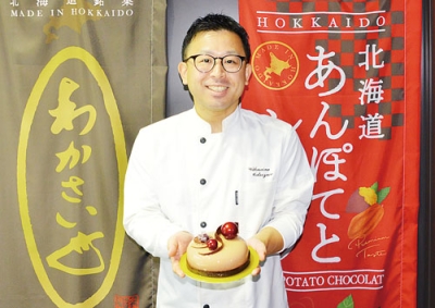 写真：入賞作品を持つ松澤さん