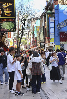 写真：横浜中華街の大通りで歩き食べを楽しむ観光客＝横浜市
