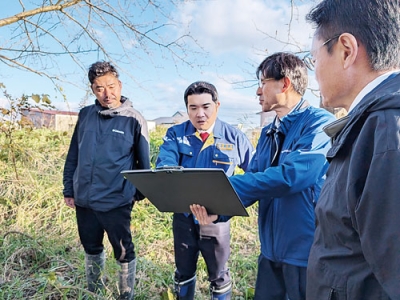 写真：町職員らから説明を受け、ヨコスト川の状況を確認する山岡氏（左から２番目）