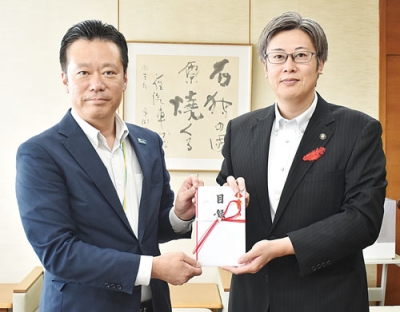 写真：「伊達市の地域振興に」と、社員らの善意を目録で手渡す髙田市場統括部長（左）