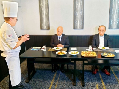 写真：シェフ（左）から料理の説明を聞く下道町長ら（提供写真）