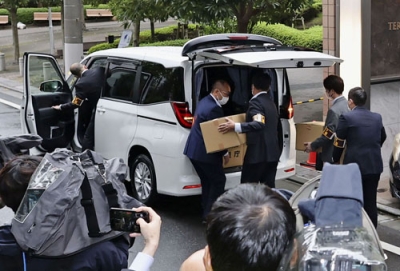 写真：「退職代行モームリ」の運営会社「アルバトロス」が入るビルから運び出した段ボール箱を車両に積み込む警視庁の捜査員ら＝２２日午前１１時３２分、東京都品川区