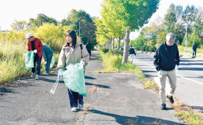 写真：イチョウが続くインター通り沿いで清掃活動に励む参加者