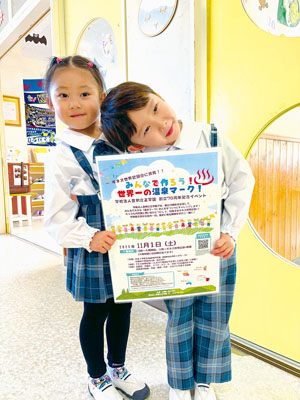 写真：参加を呼びかけるポスターを持つ園児