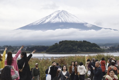 写真：山梨県富士河口湖町から見た初冠雪した富士山＝２３日午前