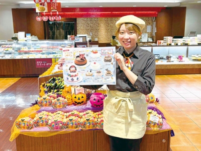 写真：ハロウィンムードの中、ひと足早くクリスマスケーキの予約開始をＰＲする佐藤さん