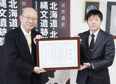 写真：感謝状を手にする永井代表取締役（右）