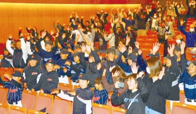 写真：石垣投手の１位指名を祝って万歳をするＰＶの来場者たち＝２３日、登別市民会館