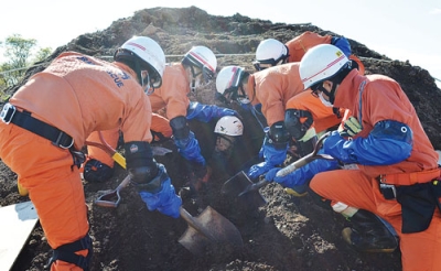 写真：災害救助の訓練で、土砂に埋まった人を救出するため慎重に掘削を進める隊員たち