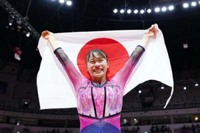 写真:体操の世界選手権女子種目別の床運動で優勝し、日の丸を掲げる杉原愛子=25日、ジャカルタ(共同)