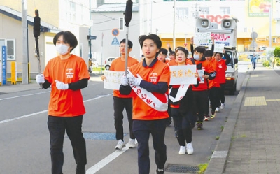 写真:平和の火をともしたトーチを掲げて走るランナー