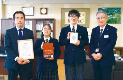 写真:川上参事(右)から百科事典を手渡された菅原さん、渡部さん、奥田校長