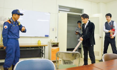 写真:屋内消火栓を使った模擬消火訓練を行う参加者