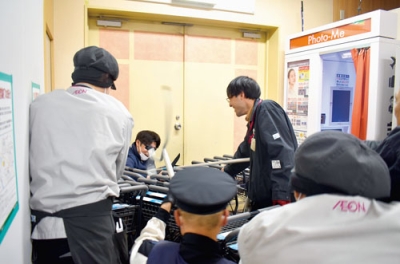 写真:ショッピングカートや刺股を使い、犯人役を制圧するイオン伊達店の店員
