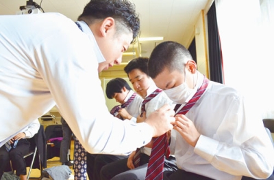 写真:ネクタイの結び方を学ぶ生徒たち