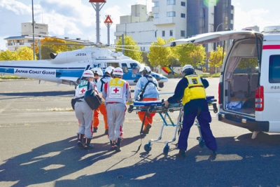 写真:重症患者を海保ヘリコプターへ搬送する訓練に臨む関係者