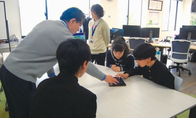 写真:職場体験でシステムの説明を受ける生徒