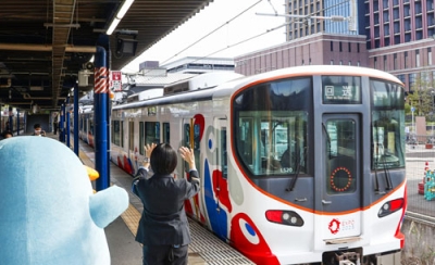 写真:JR桜島駅でミャクミャク電車を見送る駅員ら=29日午前、大阪市此花区