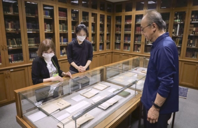 写真：小泉八雲の蔵書を集めた「ヘルン文庫」の展示を見る村上弘美さん（左）と木下晶さん（右）ら＝富山市