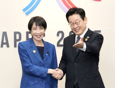 写真:会談前に握手する高市首相(左)と韓国の李在明大統領=30日、韓国・慶州(共同)