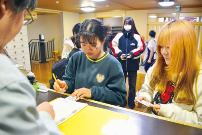 写真:さぎり湯で受け付けを行う学生ら