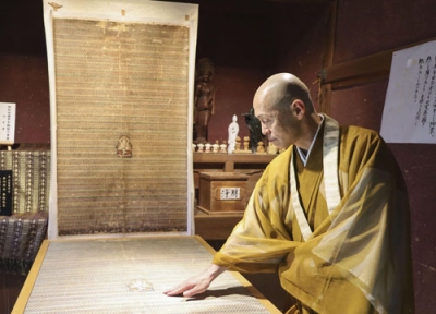 写真：長寿寺住職の藤支良道さん。奥は「地蔵曼荼羅」のレプリカ＝滋賀県湖南市