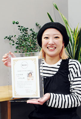 写真：北海道大会Ｕ２５特別賞の盾を手に笑顔を見せる橋本さん