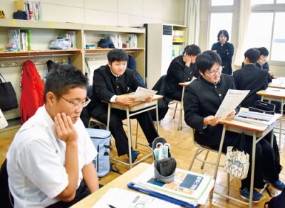 写真：ネット広告を見比べ、潜むリスクを話し合う生徒たち