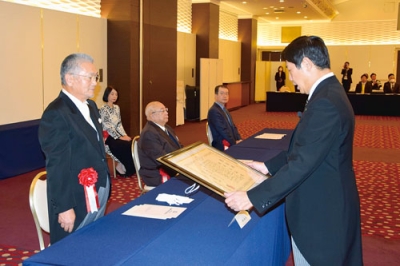 写真：市功労者として表彰される橋本さん（左）
