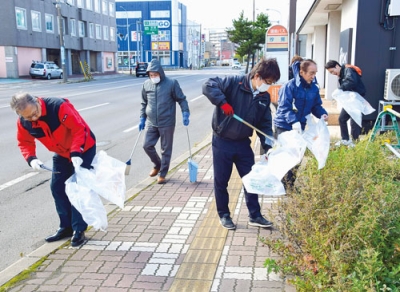 写真：道路のごみを丁寧に拾い集める参加者
