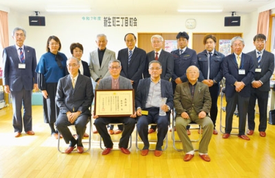 写真：国交大臣表彰の受賞を喜ぶ新生町三丁目町会や市の関係者ら