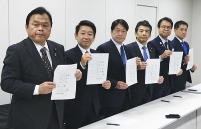 写真：協議を終え、合意文書を手に写真撮影に応じる与野党６党の税制実務者＝５日午前、国会