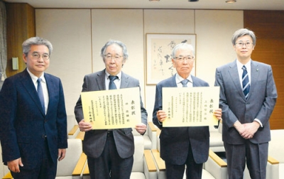 写真：表彰状を手にする上條さん（右から２人目）と坪さん