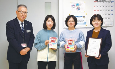 写真:川上参事(左)から国語辞典を受け取った児童代表と小野校長