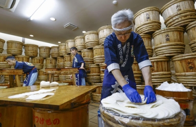 写真：京都市左京区の老舗漬物店「大安」で公開された「千枚漬」の漬け込み作業＝７日午前